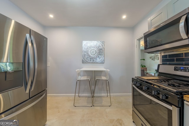 kitchen with backsplash, appliances with stainless steel finishes, baseboards, and recessed lighting
