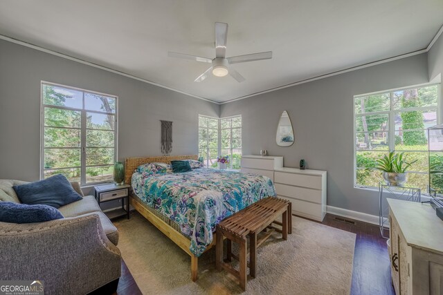 bedroom with baseboards, crown molding, multiple windows, and dark wood finished floors