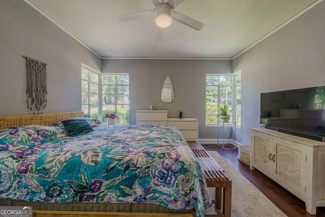 bedroom featuring baseboards, dark wood-style flooring, ceiling fan, and crown molding