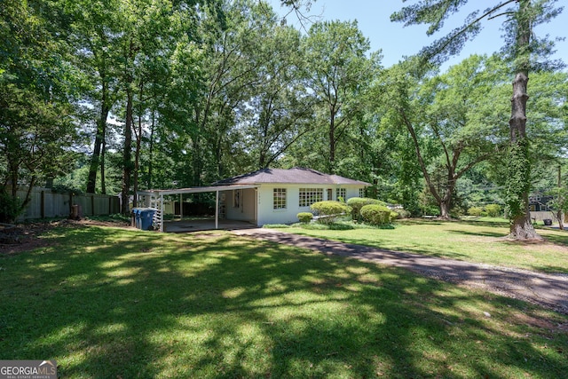 view of yard featuring an attached carport and fence