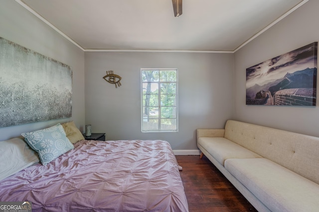 bedroom featuring baseboards, wood finished floors, and crown molding