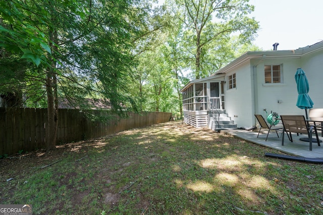 view of yard featuring a patio, a sunroom, and fence