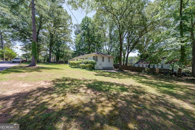 view of yard featuring an outbuilding and fence