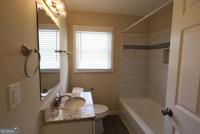 bathroom featuring vanity, toilet, baseboards, tub / shower combination, and wood finished floors