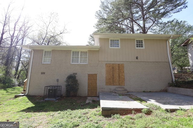 4044 Lindsey Dr, Decatur, GA 30035 - rear view of property featuring brick siding, a lawn, and a patio