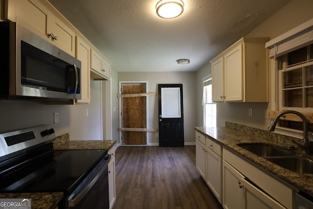 4044 Lindsey Dr, Decatur, GA 30035 - kitchen featuring stainless steel appliances, white cabinetry, a sink, stone counters, and dark wood-style floors