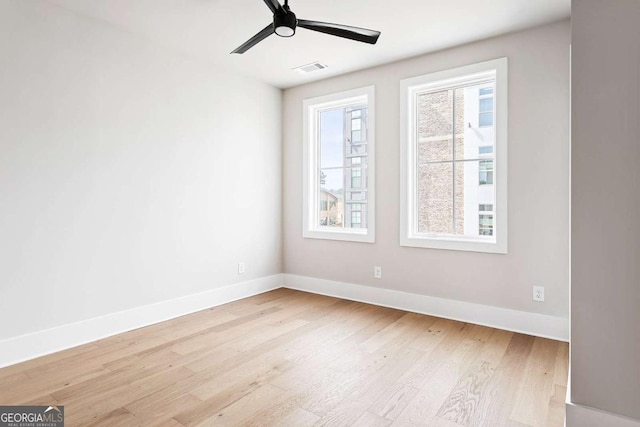 empty room featuring wood finished floors, baseboards, and a ceiling fan