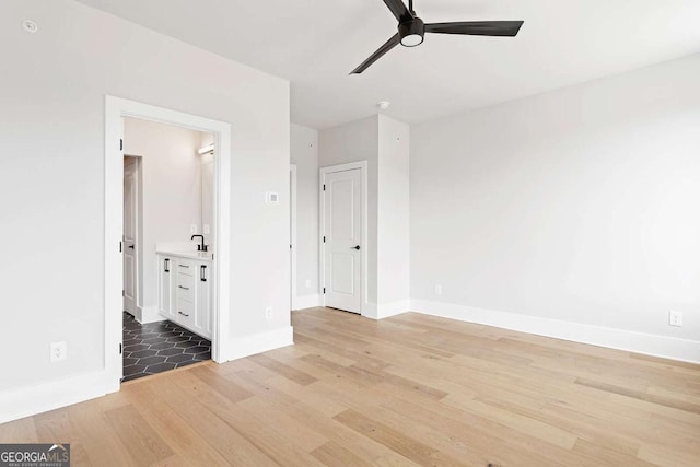 spare room featuring ceiling fan, light wood-style flooring, and baseboards