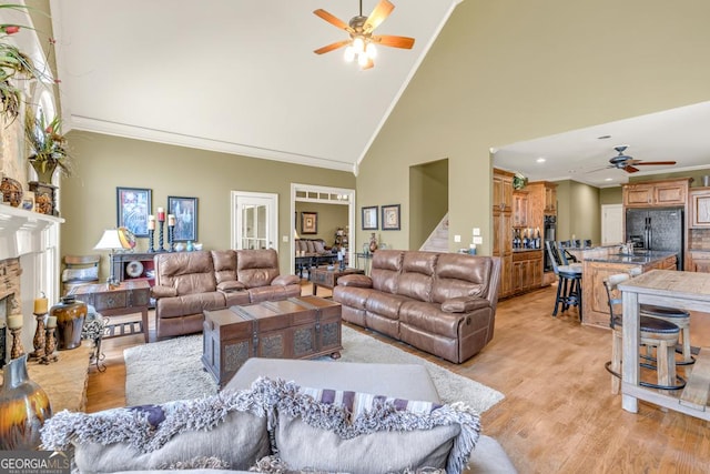 2323 Council Ln, Buford, GA 30519 - living room featuring ceiling fan, high vaulted ceiling, light wood-style floors, ornamental molding, and stairs