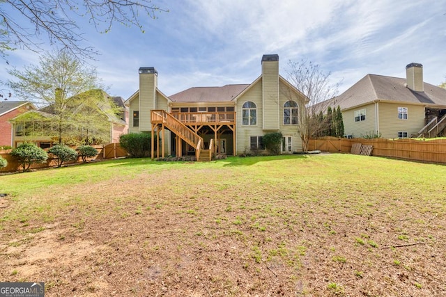 rear view of property with a fenced backyard, stairs, a wooden deck, and a yard