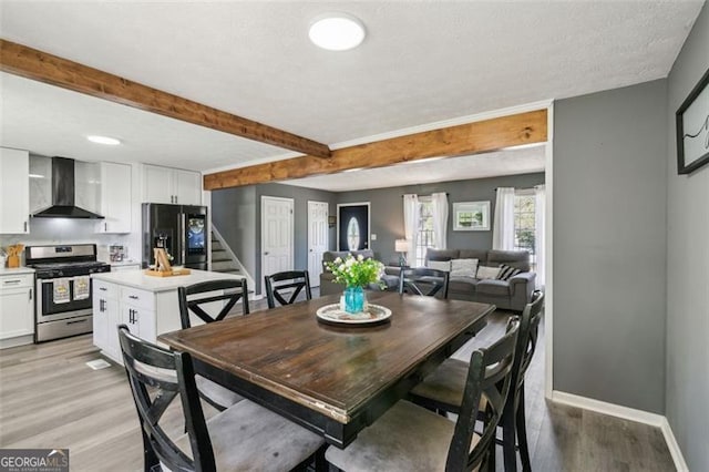 dining room with stairs, baseboards, a textured ceiling, beamed ceiling, and light wood finished floors