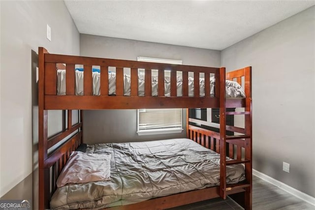 bedroom with baseboards and wood finished floors
