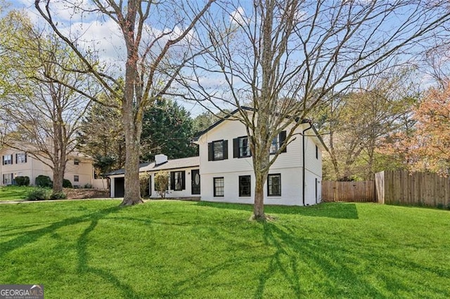 split level home with fence and a front lawn