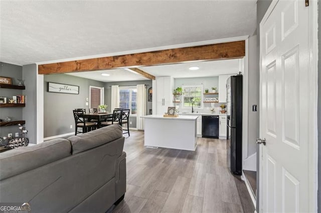 living room featuring baseboards, wood finished floors, and a textured ceiling