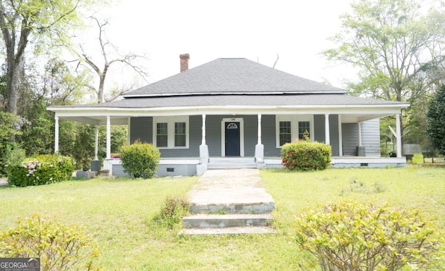 rear view of house with a lawn, crawl space, covered porch, a shingled roof, and a chimney