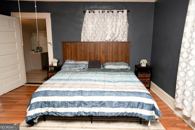 bedroom featuring baseboards and wood finished floors