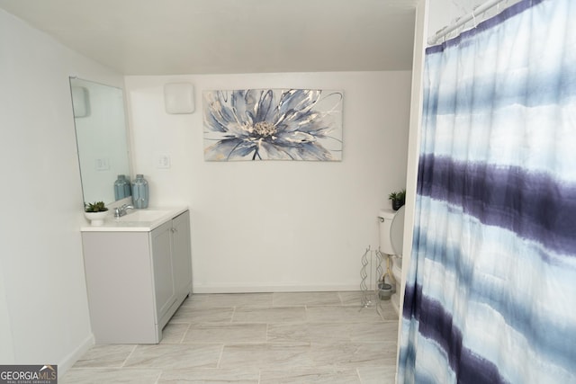 bathroom with baseboards, toilet, and vanity