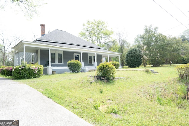 exterior space featuring a lawn, a chimney, and a porch