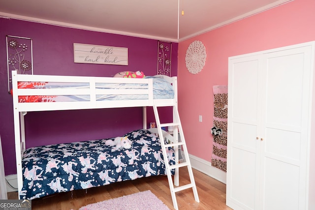 bedroom featuring crown molding and wood finished floors