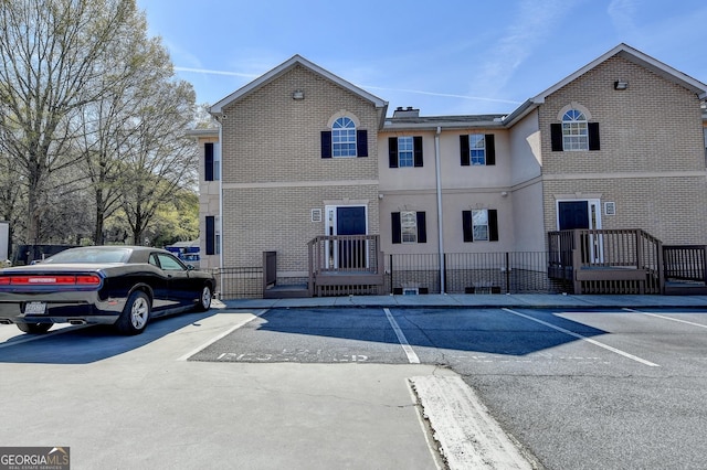 view of front of property featuring brick siding and uncovered parking