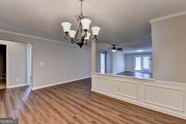 interior space featuring a textured ceiling, crown molding, wood finished floors, ceiling fan with notable chandelier, and open floor plan