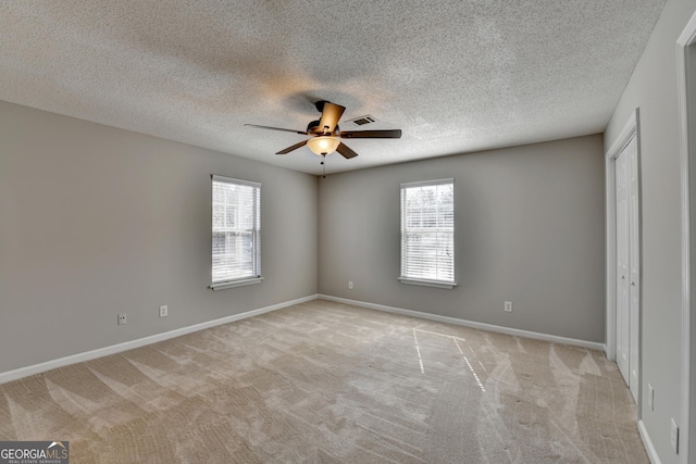 unfurnished bedroom with light carpet, baseboards, visible vents, and a closet