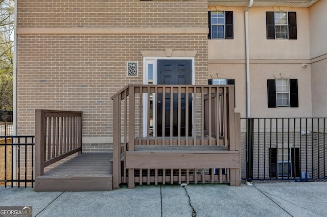 doorway to property with brick siding and stucco siding