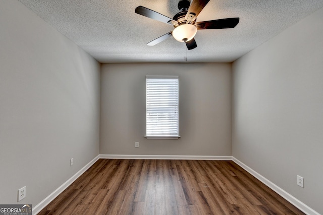unfurnished room with baseboards, wood finished floors, ceiling fan, and a textured ceiling