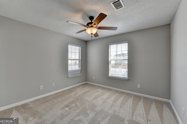 unfurnished room featuring baseboards, ceiling fan, a healthy amount of sunlight, and light carpet