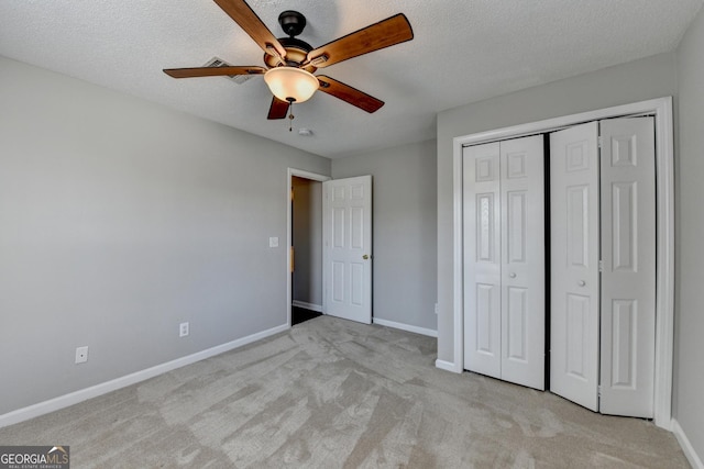 unfurnished bedroom with baseboards, a textured ceiling, and light carpet