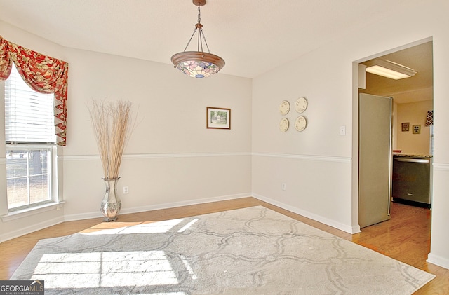 unfurnished dining area featuring light wood-style floors and baseboards