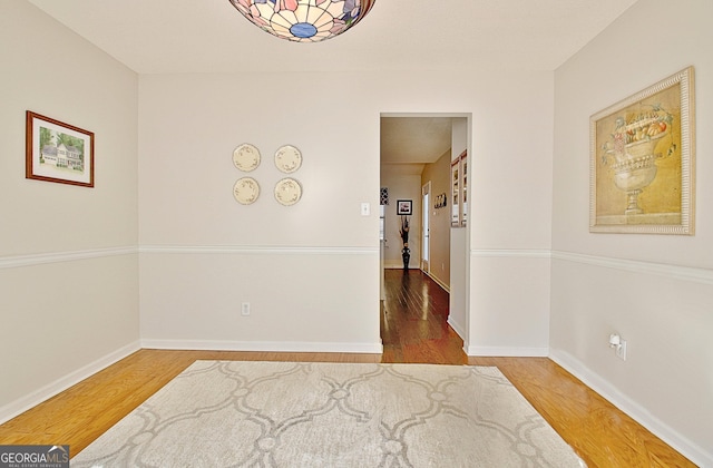 unfurnished room with baseboards and wood finished floors