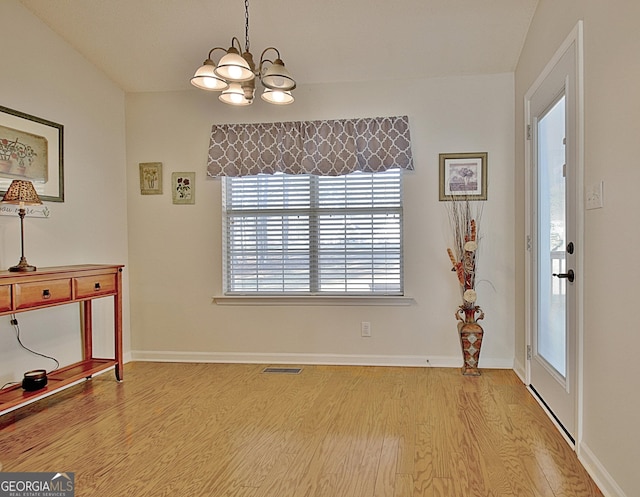 interior space with light wood-style floors, baseboards, visible vents, and a chandelier