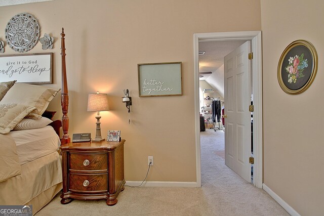 carpeted bedroom featuring baseboards and vaulted ceiling