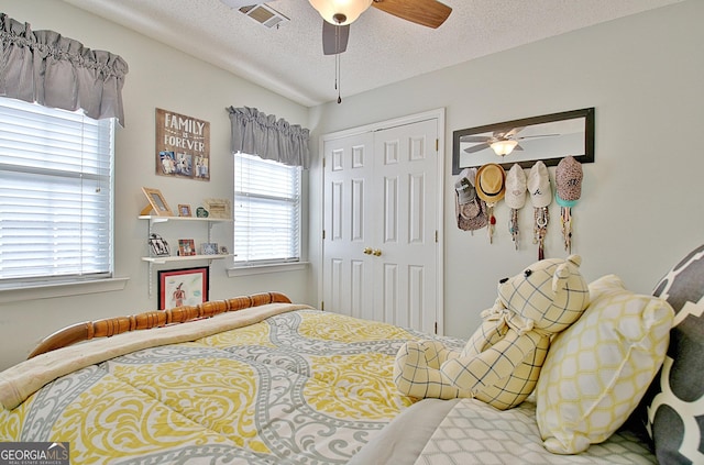 bedroom featuring visible vents, a ceiling fan, a textured ceiling, and a closet