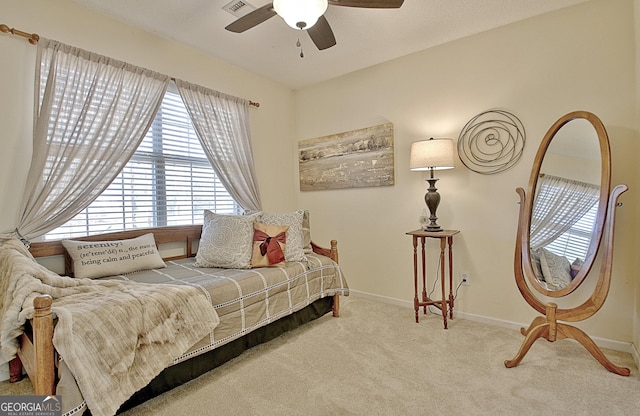 carpeted bedroom featuring baseboards, a ceiling fan, and visible vents