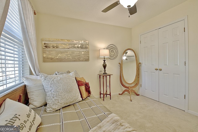 carpeted bedroom with a ceiling fan, baseboards, and a closet