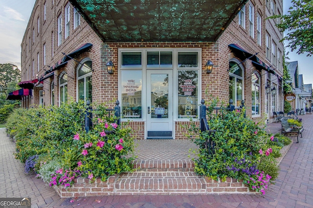 doorway to property featuring brick siding