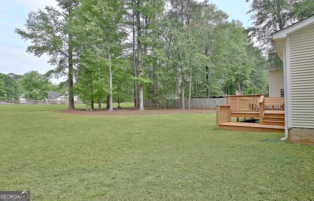 view of yard featuring fence and a deck
