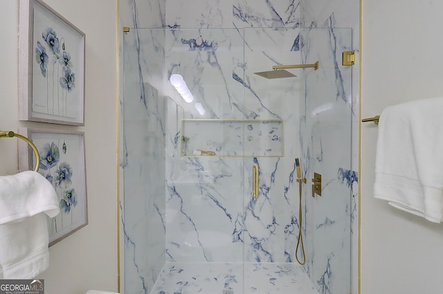 bathroom featuring a marble finish shower