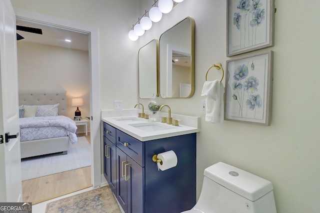 full bath with a sink, toilet, double vanity, and ensuite bath
