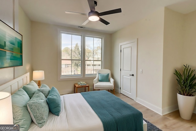 bedroom with baseboards, light wood-style floors, ceiling fan, and visible vents