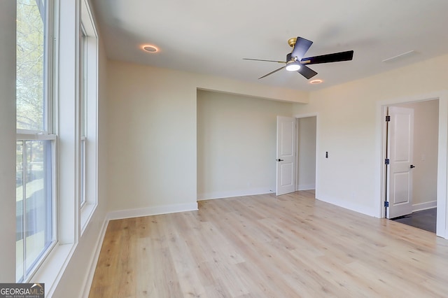 spare room with baseboards, a ceiling fan, and light wood finished floors