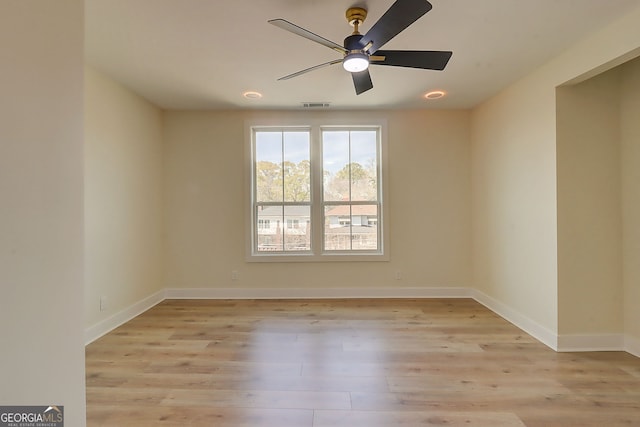 unfurnished room with baseboards, light wood-style floors, ceiling fan, and visible vents