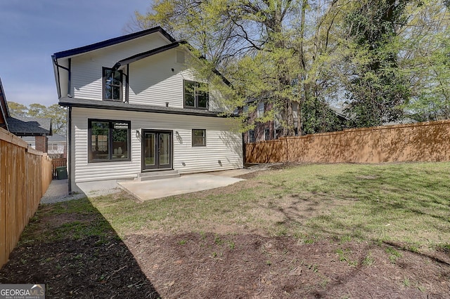 back of property with a fenced backyard, a lawn, and a patio area