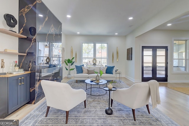 living area with light wood finished floors, baseboards, recessed lighting, and french doors