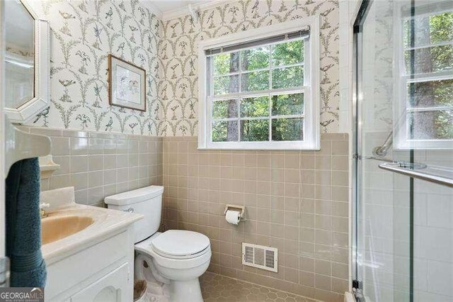 full bath featuring a wainscoted wall, toilet, vanity, visible vents, and wallpapered walls