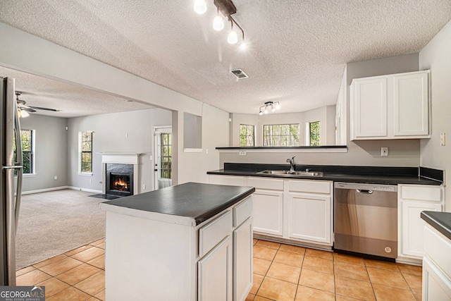 498 Pecan Wood Cir, Fairburn, GA 30213 - kitchen with stainless steel appliances, dark countertops, a textured ceiling, light tile patterned flooring, and open floor plan
