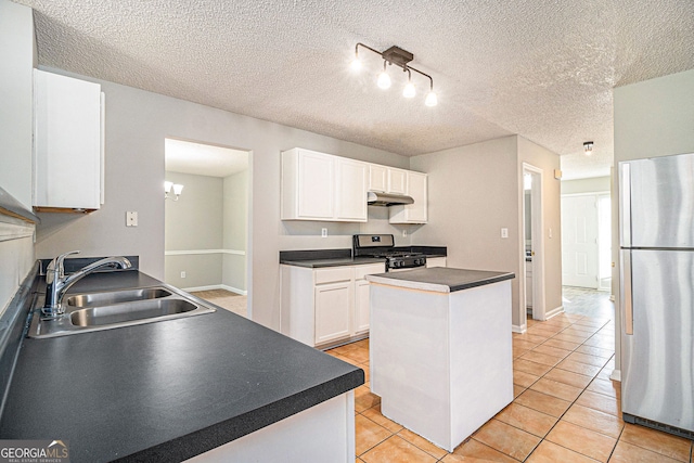 498 Pecan Wood Cir, Fairburn, GA 30213 - kitchen with appliances with stainless steel finishes, under cabinet range hood, white cabinetry, rail lighting, and light tile patterned flooring