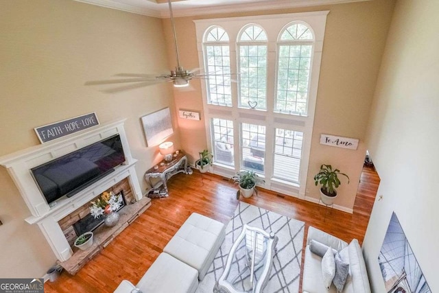 4408 Meadowwood Dr, Loganville, GA 30052 - living room with a fireplace with raised hearth, wood finished floors, a healthy amount of sunlight, and a ceiling fan